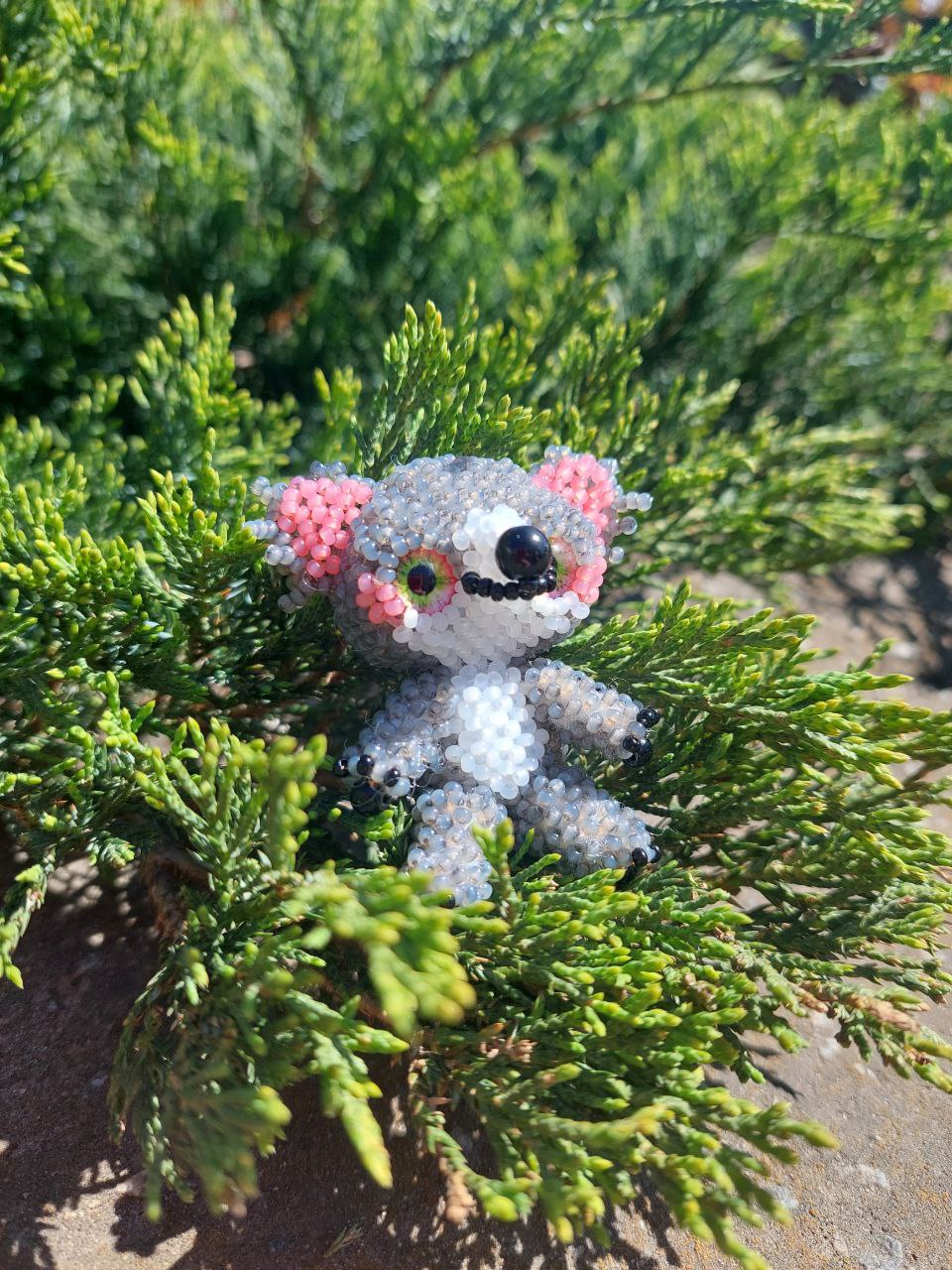 Коала з бісеру серед зелені на фоні природи